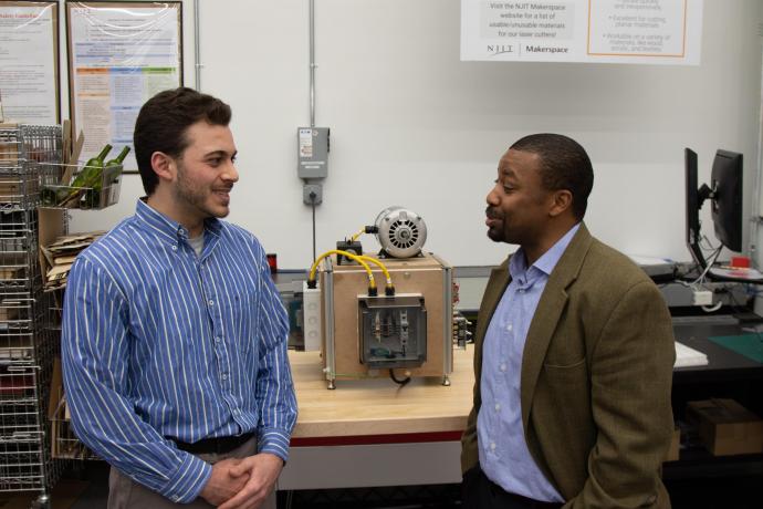 Matthew Berdel, a systems engineer and program trainee, and Professor ShaQueel Dyer describe the machine they built in class, complete with a machine frame, electrical enclosures, an AC motor, lockout-tag-out safety features and an LED light panel with switches.