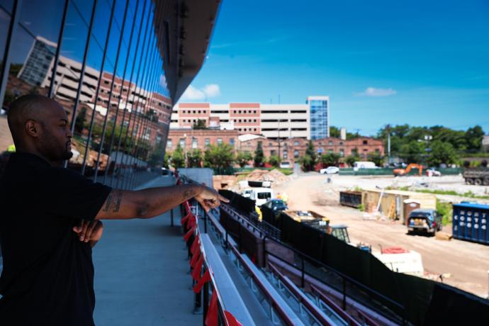 From outside NJIT’s Wellness and Events Center, Wilson looks out on the torn-down Zoom Fleisher Athletic Center, currently being transformed into a state-of-the-art athletics field.