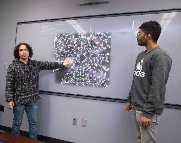 Ph.D. student Santiago Flores Roman is discussing molecular simulation of carbon dioxide in zeolite pore space with undergraduate researcher Geordy Jomon.