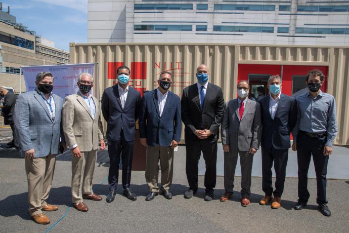 U.S. Senator Cory Booker (fifth from left) joins members of the New Jersey consortium that developed a mobile medical care unit from repurposed shipping containers to deploy to areas in need of health care infrastructure.