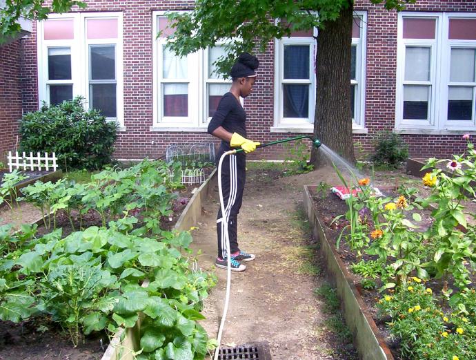 Recent STEM Academy graduate Renieal Campbell volunteers in the school’s sustainable garden.