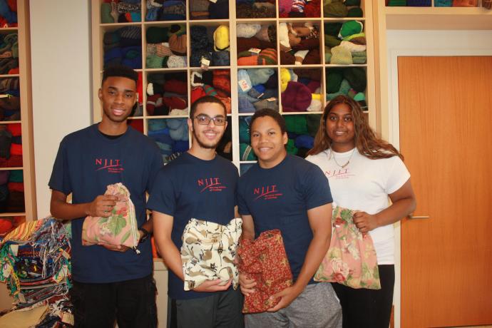 Cameron Bennett, Keith Montalvo, Brandon Chin and Kamela Chandrika preparing holiday gifts for mariners far from home.