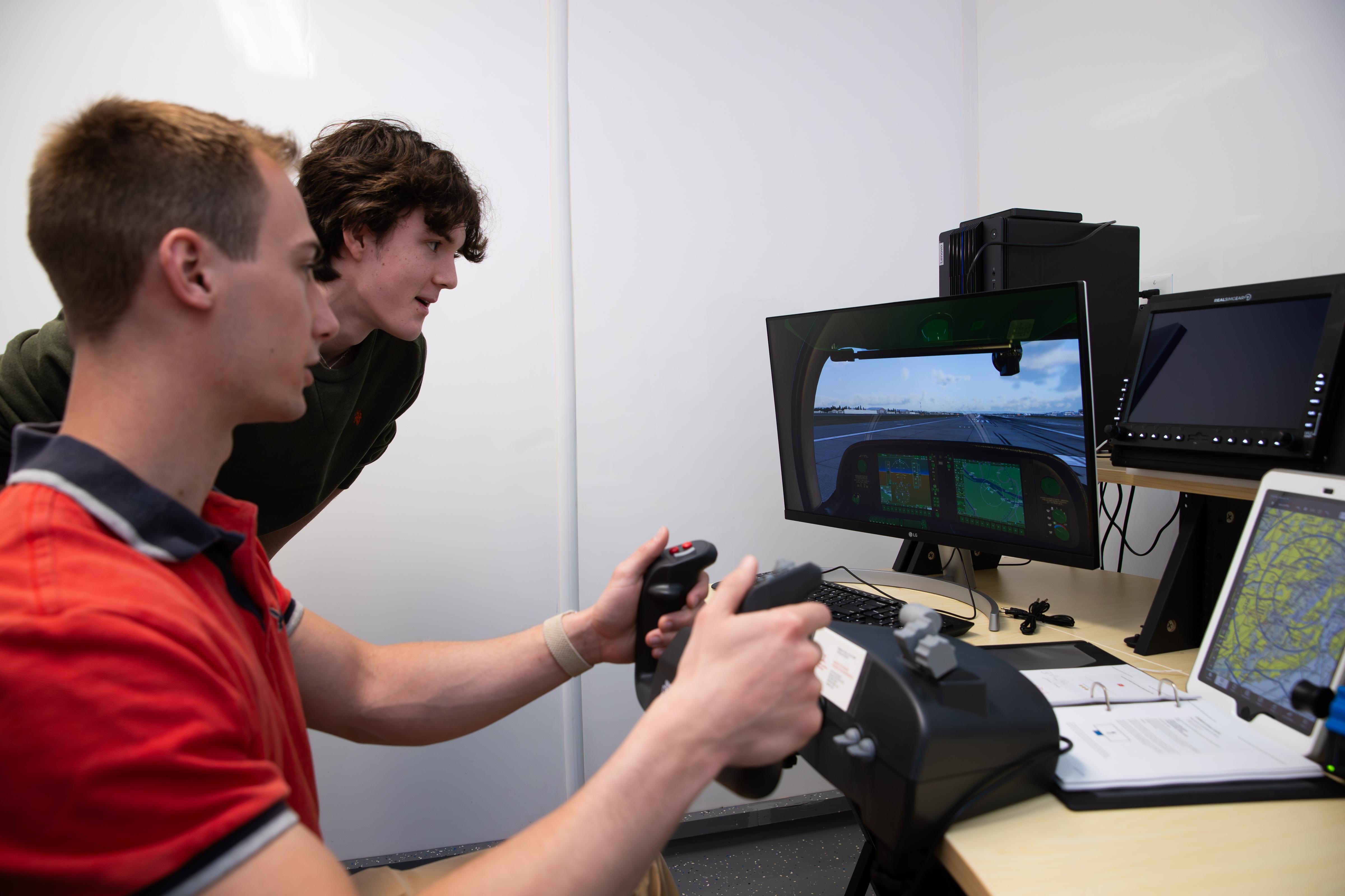 Aviation club students demonstrating flight simulation equipment