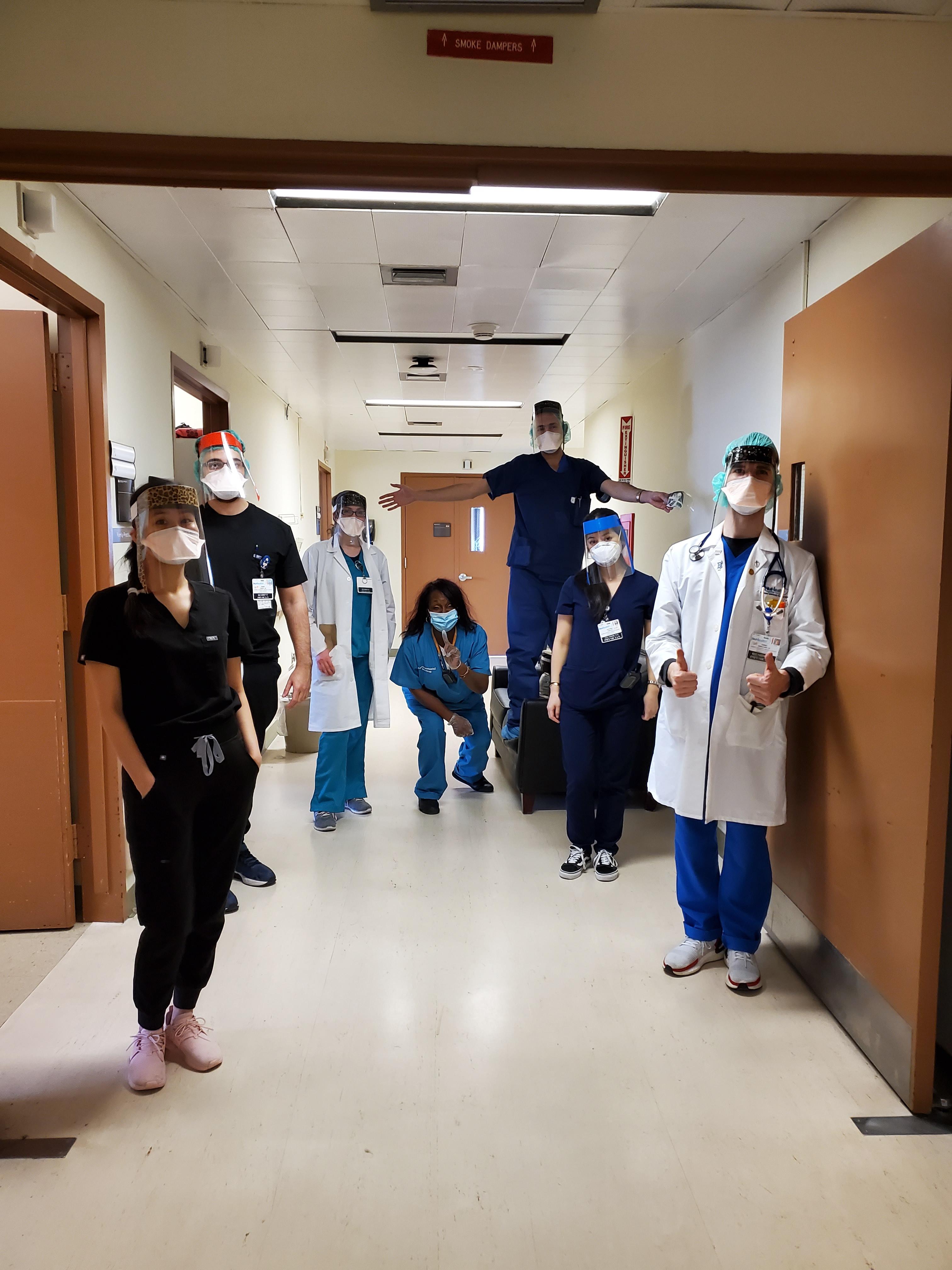 Honors alumnus Daniel Meshoyrer, D.O. (front right), and his Nassau University Medical Center colleagues wear the shields produced by Honors student Greg Tanis.