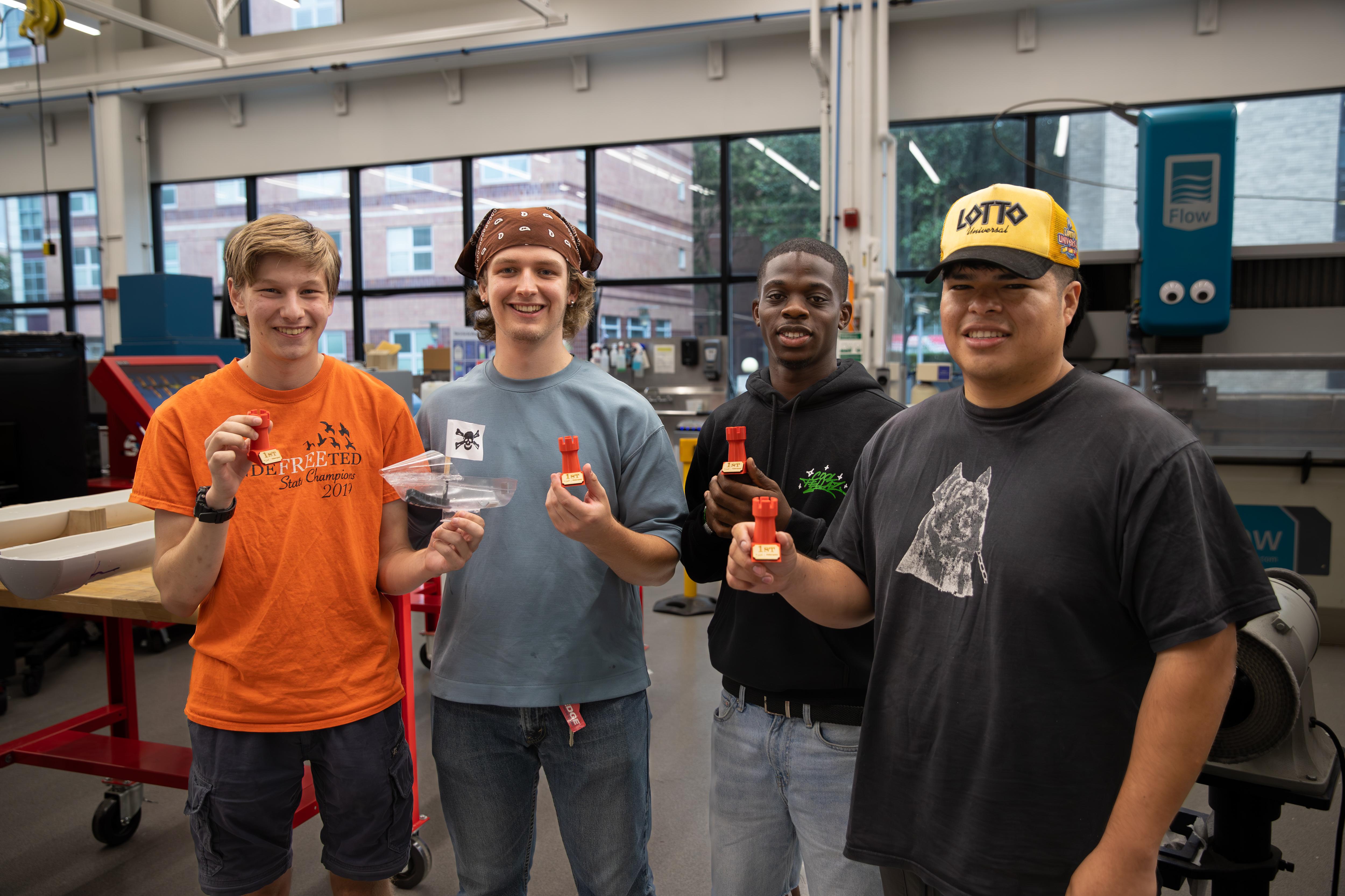 The winning team of Josh Rutka, Nathan Steinberg, Afolabi	Adeliyi, and Sebastian Chirinos with their boat 