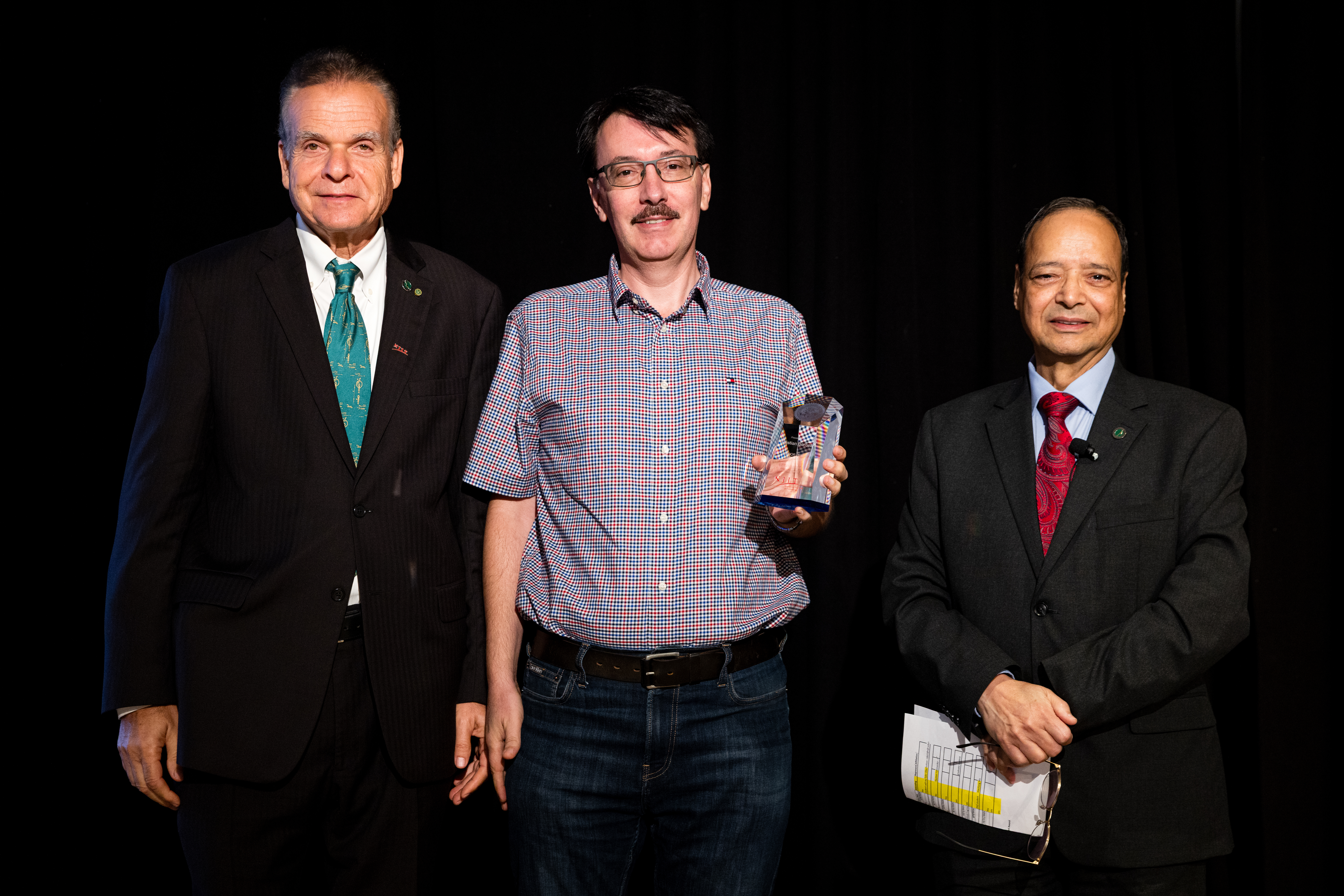 NAI member and NJIT professor Cristian Borcea (center) accepted a patent award from Sanberg (L) and Dhawan (R). 