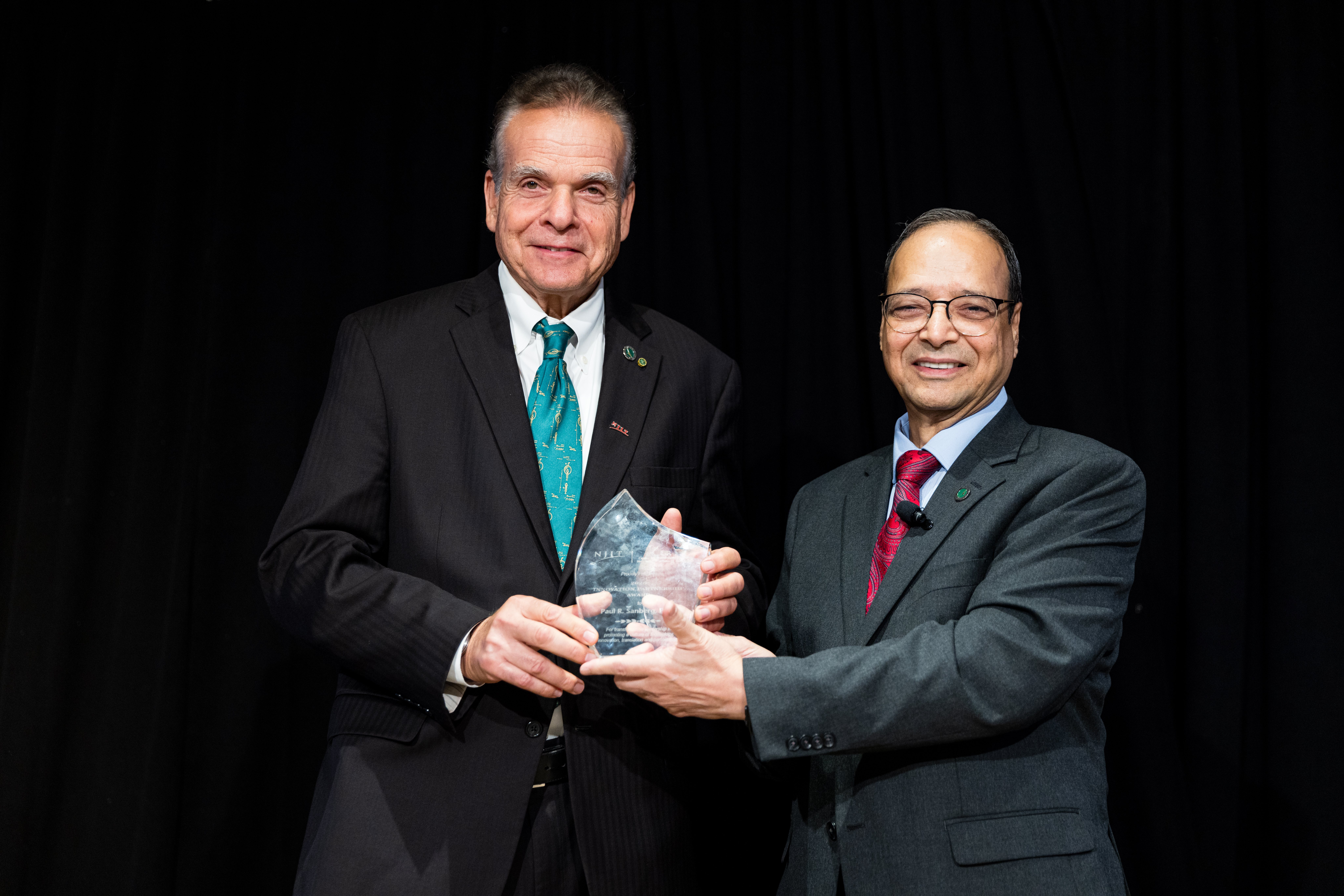 Atam Dhawan (R) presented Paul Sanberg (L) with the 2026 Innovation Partnership Award.