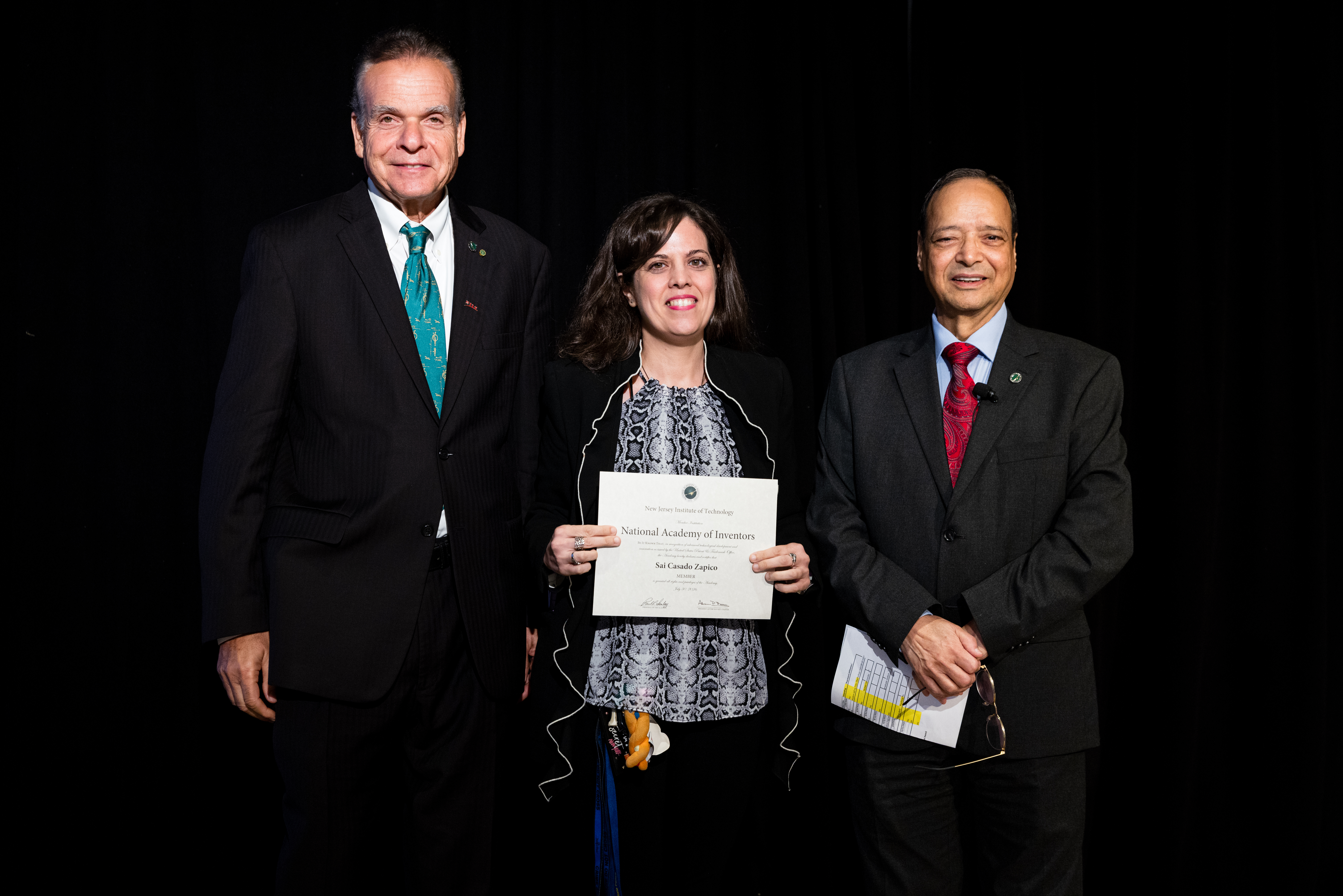 Sai Casado Zapico (center), an NJIT assistant professor in the Department of Chemistry and Environmental Science, holds a NAI membership certificate.
