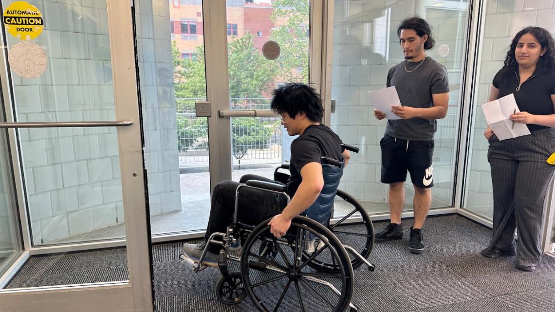 Students testing doorway design for wheelchair compatibility