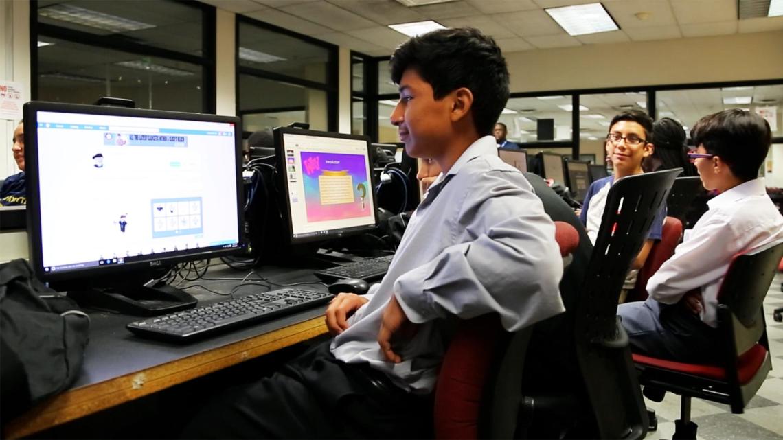 Pre-college students working on computers.