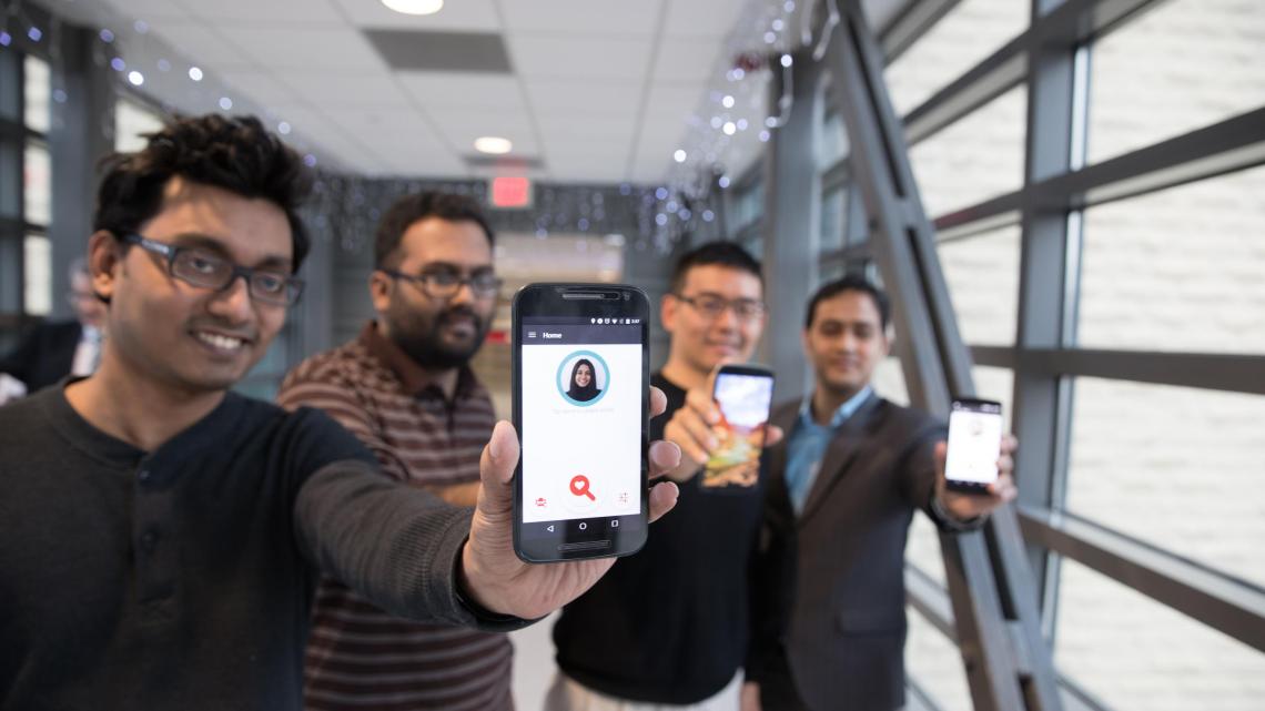 four students hold up smartphones featuring FaceDate