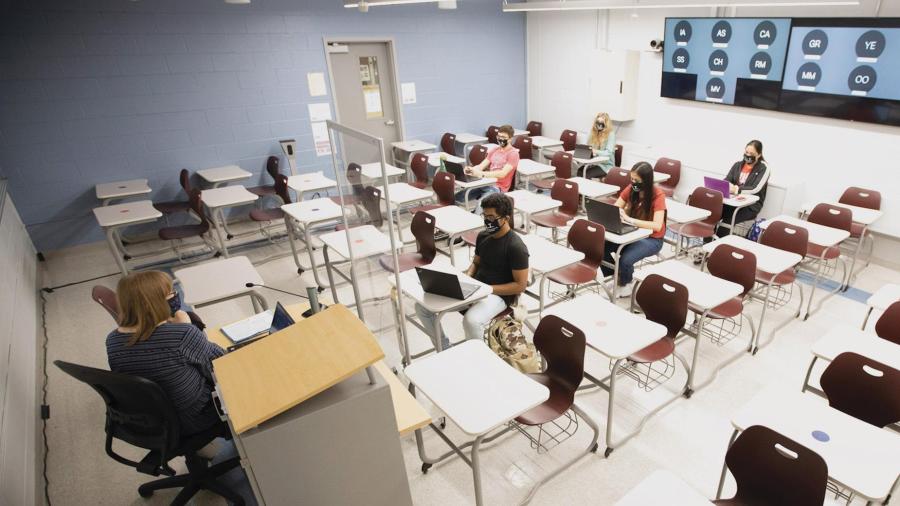 University Lecturer Catherine Siemann conducts her Honors Humanities class with students attending either in person or, via the back-wall screen, from a virtual location.