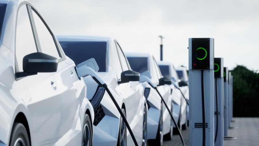 Several electric vehicles lined up at charging stations.