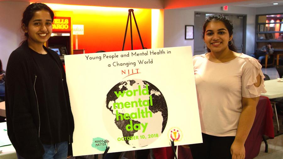 Mehak Farrukh, Minds Matter event planner (left), and Charu Arya, Minds Matter student president, publicize the new club and World Mental Health Day in the Campus Center.  