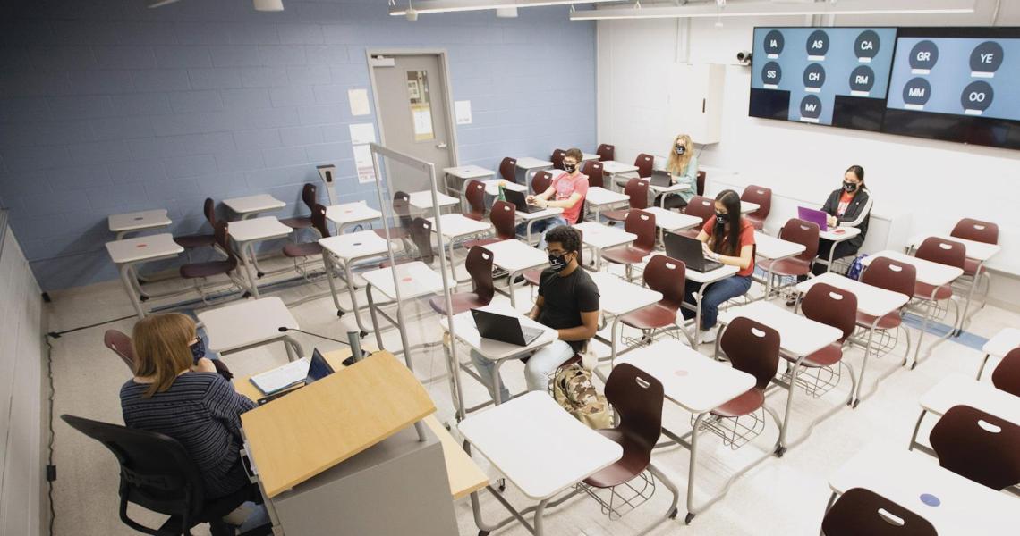 University Lecturer Catherine Siemann conducts her Honors Humanities class with students attending either in person or, via the back-wall screen, from a virtual location.