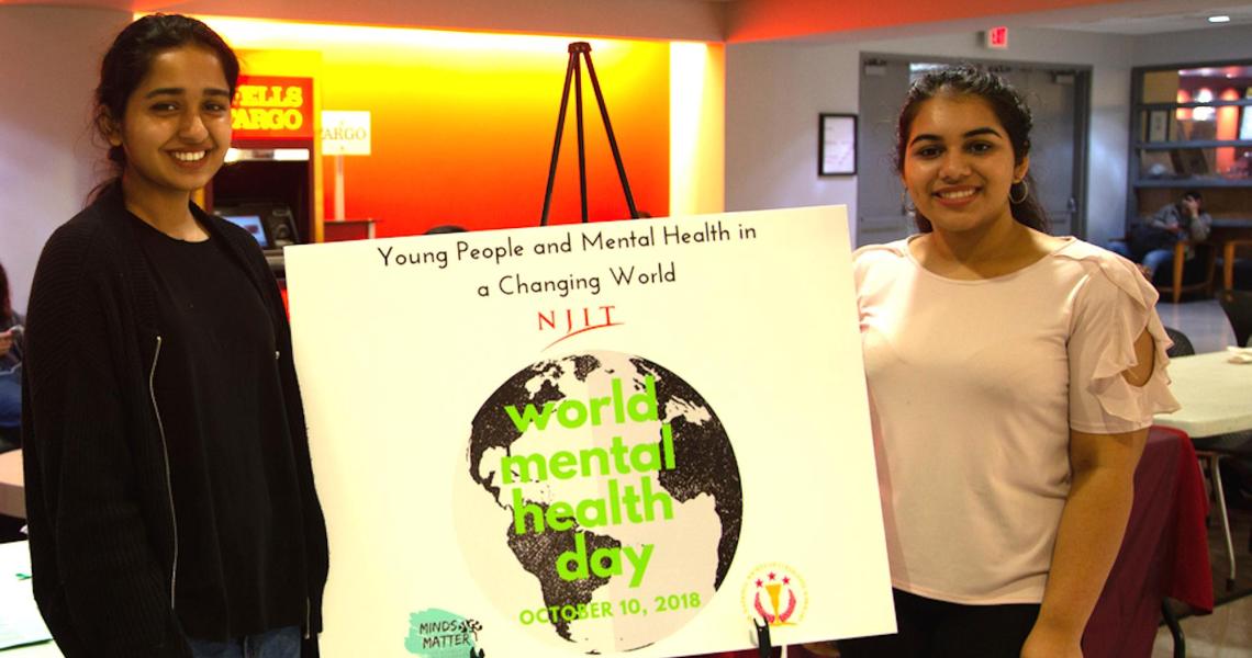Mehak Farrukh, Minds Matter event planner (left), and Charu Arya, Minds Matter student president, publicize the new club and World Mental Health Day in the Campus Center.  
