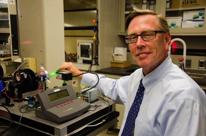 Dean Kevin Belfield with equipment used to evaluate the photostability of fluorescent probes formulated at NJIT as part of the effort to develop new, minimally invasive diagnostic technology.