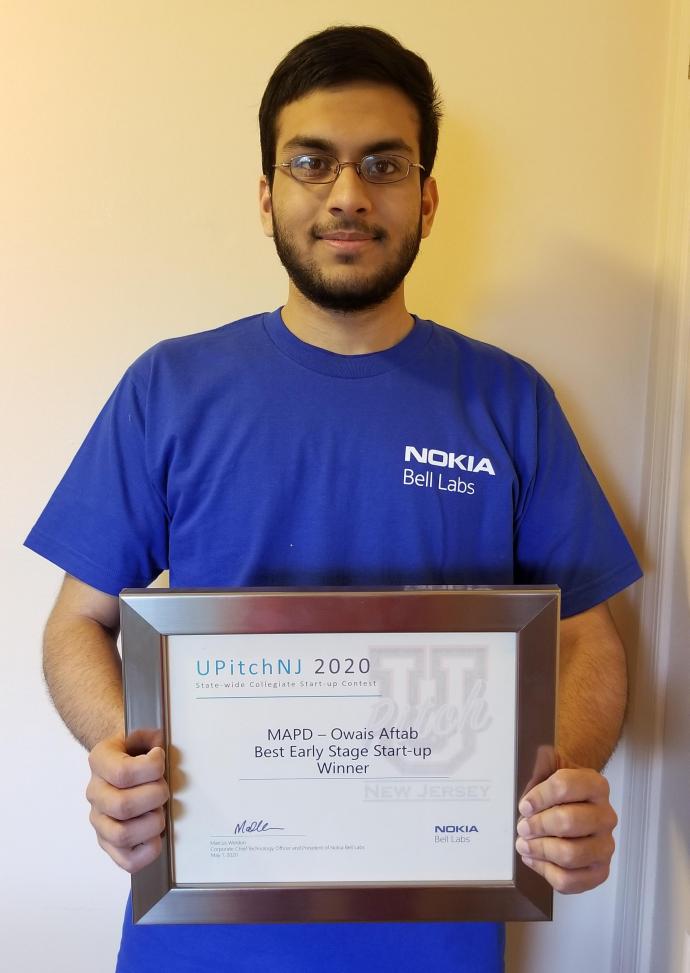 Owais Aftab holds MAPD's UPitch plaque.