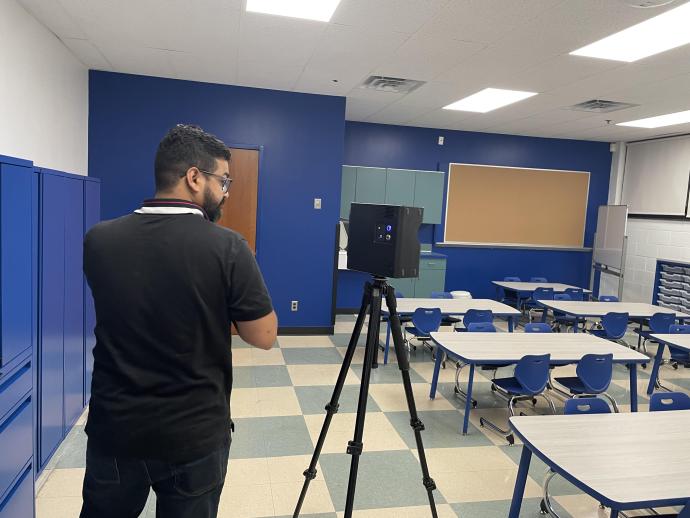 Satia Anand B.Arch. ’23, operating a Matterport camera to document a classroom.