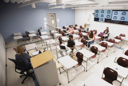 University Lecturer Catherine Siemann conducts her Honors Humanities class with students attending either in person or, via the back-wall screen, from a virtual location.