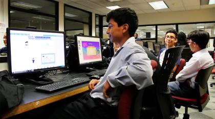 Pre-college students working on computers.