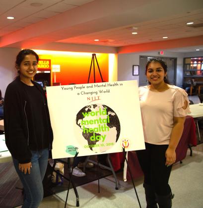 Mehak Farrukh, Minds Matter event planner (left), and Charu Arya, Minds Matter student president, publicize the new club and World Mental Health Day in the Campus Center.  