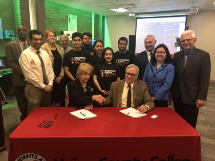 Maris Lown (seated left), vice president of academic affairs, Union County College, and Fadi P. Deek, provost and senior executive vice president, NJIT, shake on it after signing a joint academic agreement between the two institutions. 