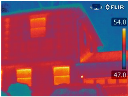 Infrared image of poorly insulated house losing heat. 