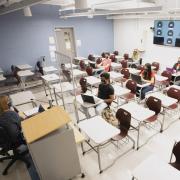 University Lecturer Catherine Siemann conducts her Honors Humanities class with students attending either in person or, via the back-wall screen, from a virtual location.