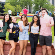 Seven NJIT students holding cotton candy on the campus green during move-in weekend