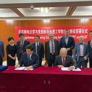 Jianyong Qiao, BUPT president (seated left), and Joel S. Bloom, NJIT president (seated right), sign agreements between the two universities as faculty and staff look on.