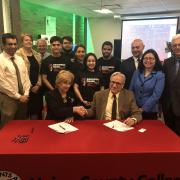 Maris Lown (seated left), vice president of academic affairs, Union County College, and Fadi P. Deek, provost and senior executive vice president, NJIT, shake on it after signing a joint academic agreement between the two institutions. 