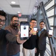 four students hold up smartphones featuring FaceDate